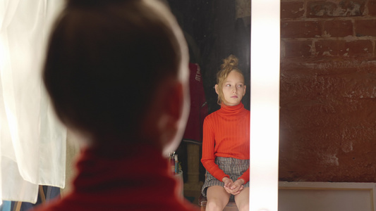 年轻女孩在美发工作室前镜中接受发型时尚造型师在沙龙视频