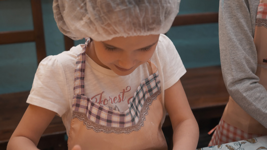 年轻女孩在烹饪学校的烹饪课上为意大利比萨卷面团快乐视频