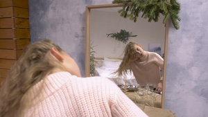 穿着粉红毛衣的年轻女孩在镜子前玩耍26秒视频