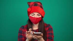 穿着圣达克萨斯帽的妇女脸上戴着医疗面具在智能手机上11秒视频