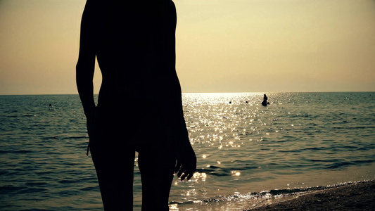 日出日落时在海边散步的冲浪女孩视频