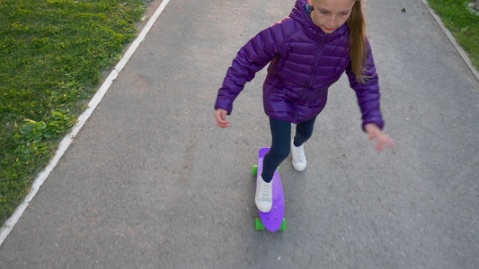 年轻的溜冰女孩骑在城市慢动作滑板上从上面看女孩少年视频
