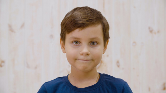 小男孩微笑着只嘴唇在光工作室的镜头前特写肖像可爱的视频