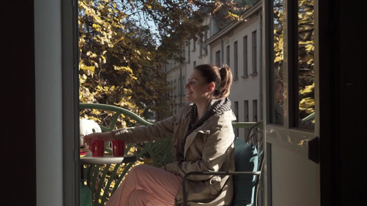 年轻白人女子在阳光明媚的秋天坐在露天阳台上享受茶叶视频