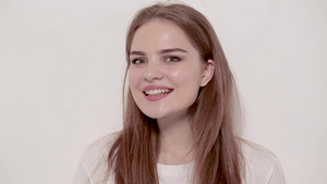 年轻女性在白色背景上装扮和微笑8秒视频