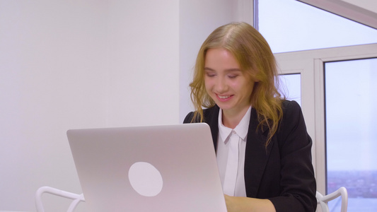 在商业办公室工作时使用膝上型计算机的快乐的商业妇女视频