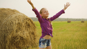 快乐的女孩在干草堆背景上向天空伸出手来少女在农村收获11秒视频