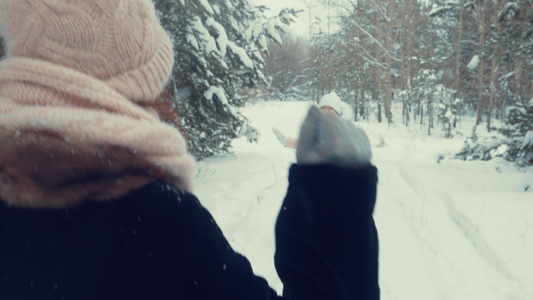 快乐的女孩奔跑在雪林中拥抱视频