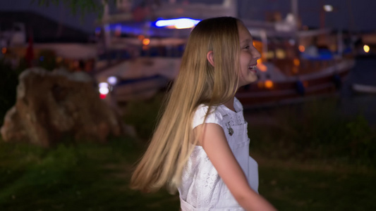 快乐的女孩在晚上的街道上跳舞和唱歌视频