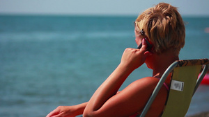 女人在沙滩的电话上说话15秒视频