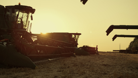 在日落麦田农田的机械设备剪影视频