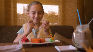 快乐的少女在餐馆用筷子吃寿司卷8秒视频