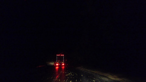 大卡车货车在城市外的农村公路上晚上雨后湿滑的道路上27秒视频