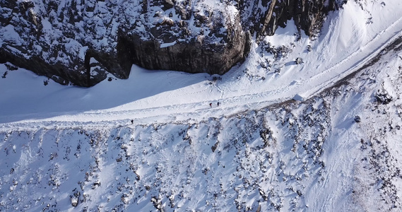一群人爬上峡谷的雪道视频