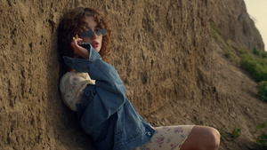 迷人的女孩靠在沙崖上戴着低太阳镜特写镜头9秒视频
