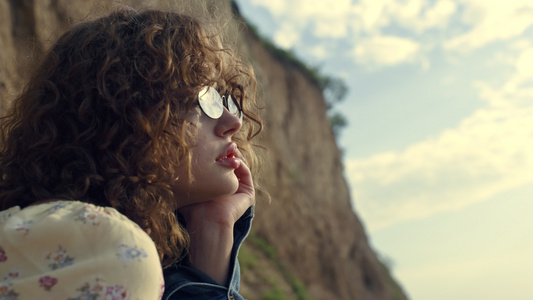 梦幻般的女人肖像坐在海边的太阳镜视频