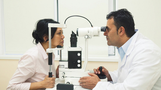 一名熟练的医生用设备检查病人的眼睛并使用器械检查患者视频