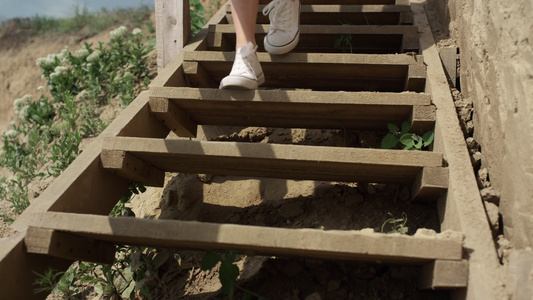 苗条的女孩腿穿着白色运动鞋跑下海滩楼梯视频