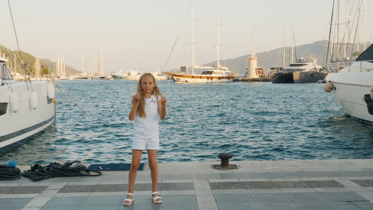 性格开朗的少女少年在海港和游艇背景的码头上跳舞快乐视频