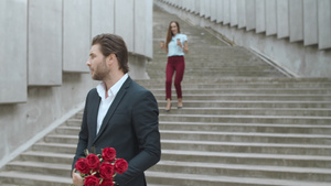 手捧玫瑰的男生等待赶来赴约的女友29秒视频