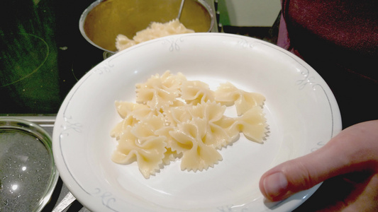 女孩把煮的意大利面放在盘子上视频