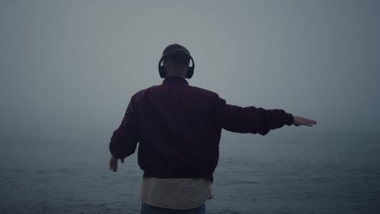 活跃的人在有雾的海滩上跳舞耳机视频