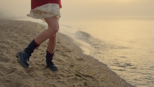 在海滩上跳跃的靴子的时尚女孩视频