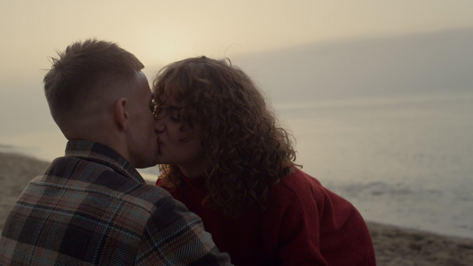 浪漫的情侣在日出时在海滩上接吻视频