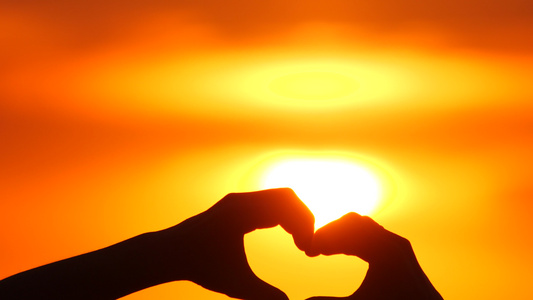 爱标志或手势在日落和阳光透过心在度假时手工制作在浪漫视频