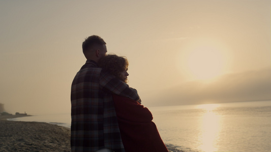 浪漫的女人和男人在日出时站在海滩上视频