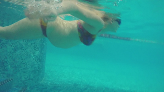 孕妇在游泳池中游泳时的水下视图视频