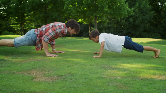 父亲和儿子在公园里做俯卧撑视频