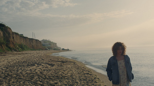 悲伤的女人在日落时沿着大洋彼岸行走24秒视频