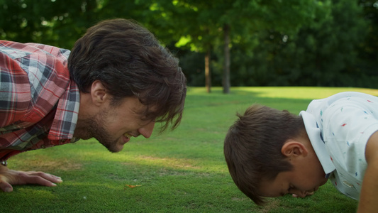 父亲和儿子在公园里做俯卧撑视频