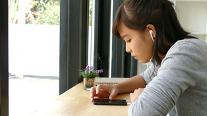 穿戴耳机和在智能电话中听音乐的年轻女青年学生使用耳机13秒视频
