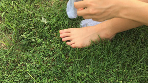 妇女穿着绿草背景的袜子10秒视频