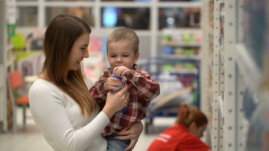 年轻母亲和儿子在商店或超市买水视频