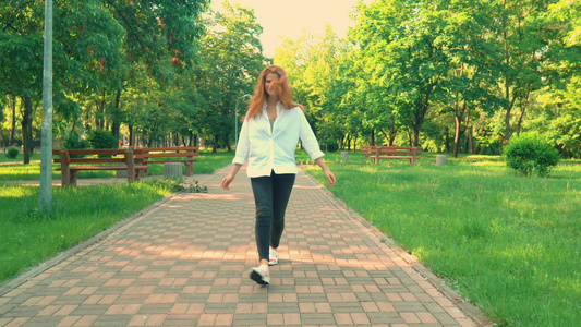 闲暇时间红发女孩在公园散步视频