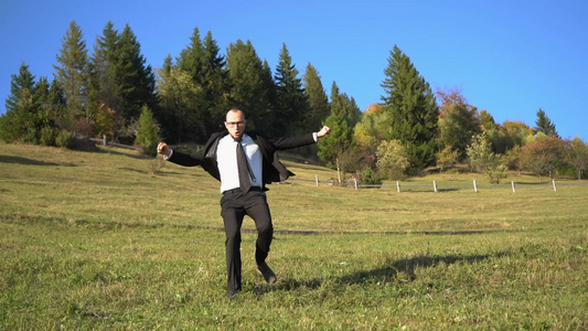 一个穿黑色正装的男人跑下山丘慢动作视频视频