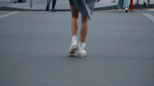 女孩双腿在市中心街道的人行横道上过马路视频