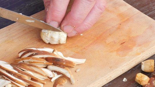 男厨师切新鲜野生蘑菇用刀切蘑菇的手特写镜头人手小心视频