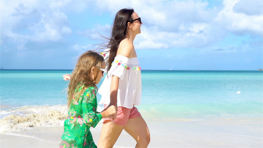 家庭在热带海滨上行走的喜菜海滩上的母亲和女儿视频