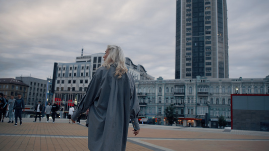 女性在晚上步行城市广场与城市建筑视频