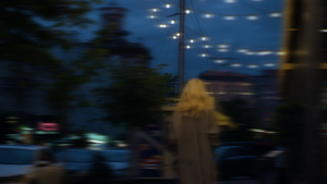 在城市背景建筑中行走的女士晚上城市灯光7秒视频