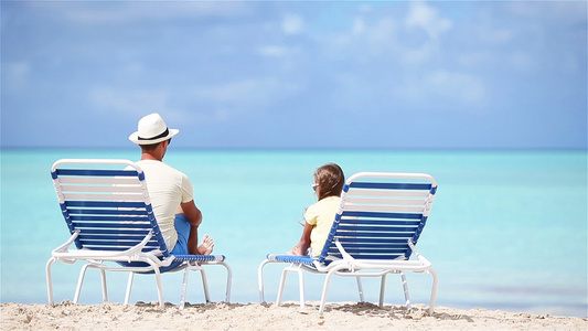 父亲和女儿亲手在沙滩上坐着长座椅视频