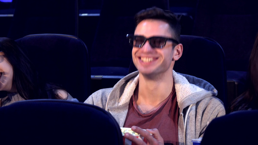 男的坐在两个女孩中间在电影院视频