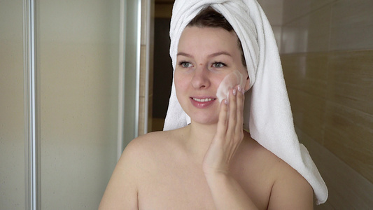 洗脸的女人在浴室用泡沫洗脸视频