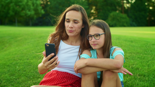 母亲和女儿在夏季田间用手机通过视频电话在网上聊天视频