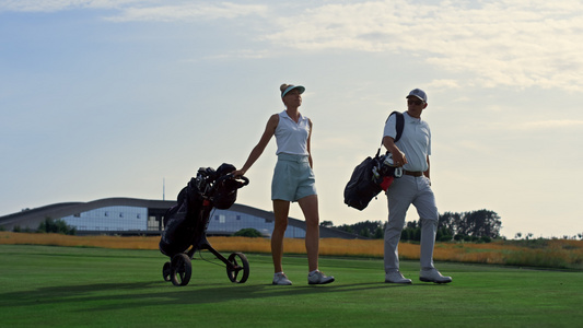 高尔夫专业人士一起在草地球场散步视频
