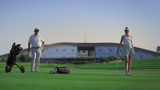 商务夫妇在球场上打高尔夫球视频